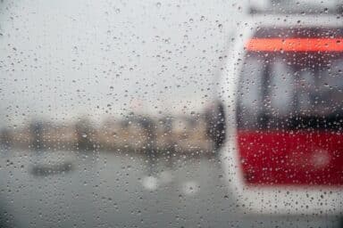 A glimpse of a train moving past a rain-soaked window, illustrating the fears of avoidant personality disorder (AVPD).