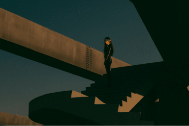 A solitary person stands on a concrete stairway in a minimalist urban setting, wondering how to deal with anxiety.
